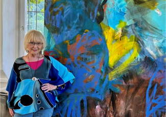 Renate Gehrcke steht vor einem Ihrer Kunstwerke